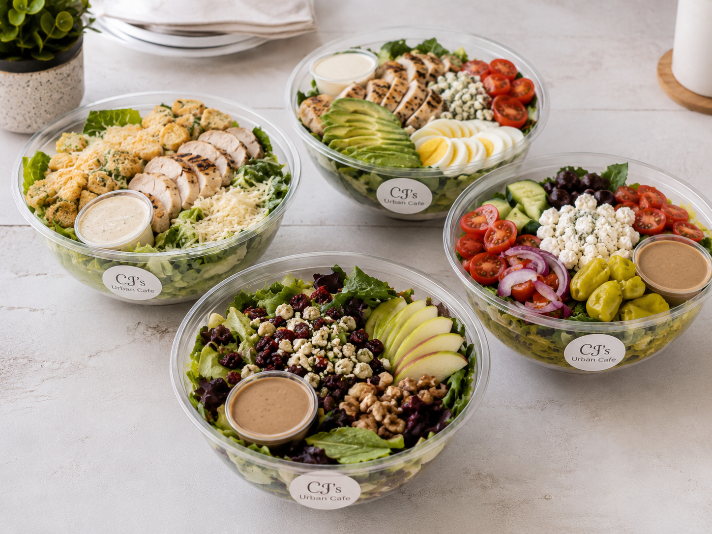 CJ's Urban Cafe premium salad bowls — Cobb, Chicken Pecan, and seasonal varieties